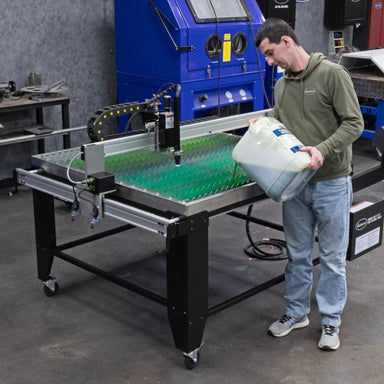 Man Pouring Eastwood CNC Plasma Cutting Table Fluid - 5 Gallon into CNC Table