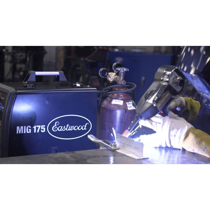 Person welding metal with an Eastwood MIG 175 welder in a workshop setting. Eastwood MIG Welder Spool Gun with Metal Connector