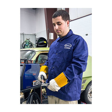 Eastwood blue Welding jacket  working on a vehicle in a garage.