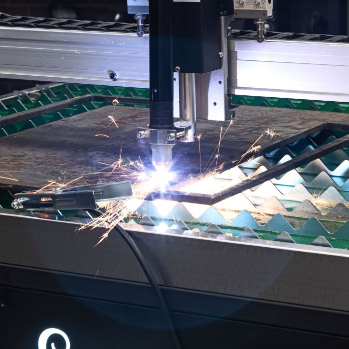 Close-up of the CNC plasma torch cutting metal on the Eastwood Versa-Cut 5x5 table
