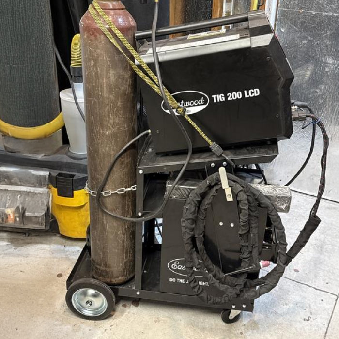 Eastwood welding cart in a fabrication workshop holding welding equipment and accessories.